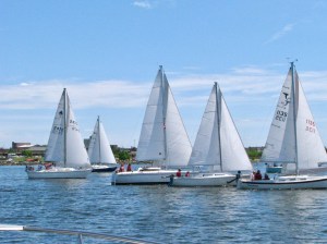 Group of sailboats racing on a lake.